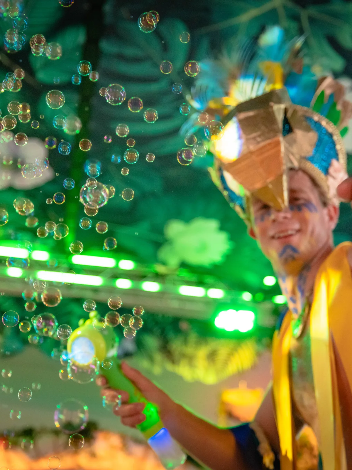 A dancer in a gold headdress surrounded by bubbles