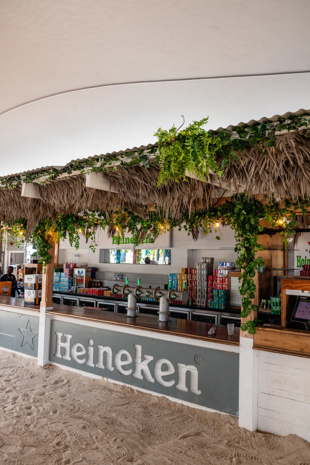 A tropical beach bar with hanging greenery at Alcazar