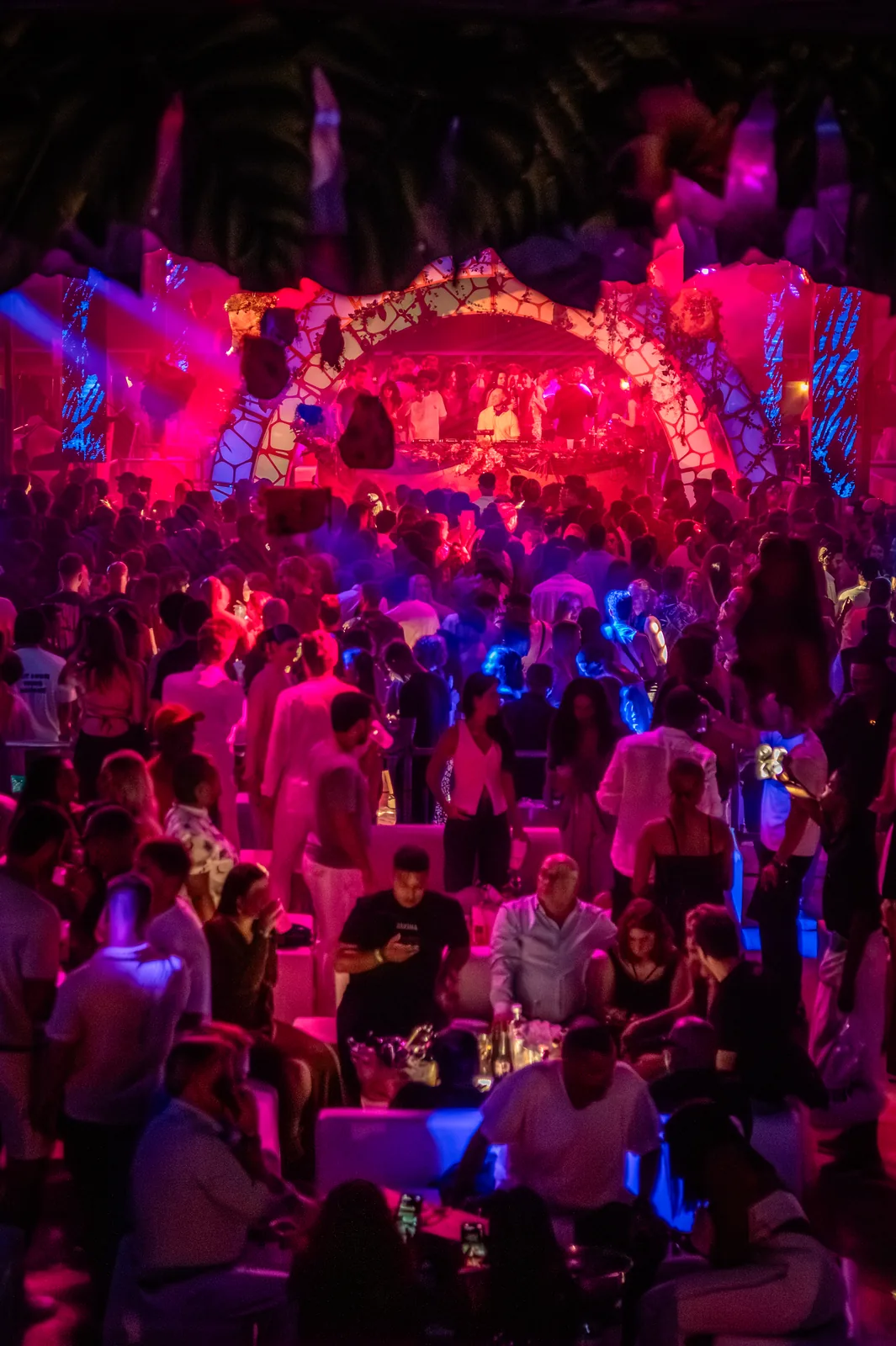 Guests dancing under pink and blue lights in the VIP area